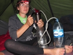Alena pumpt abends im Zelt fleissig Wasser.
